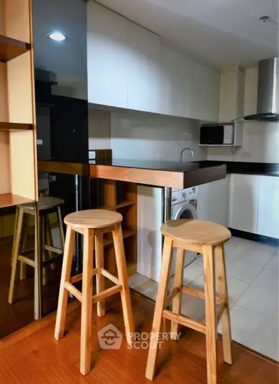 Modern kitchen with wooden stools and sleek cabinetry