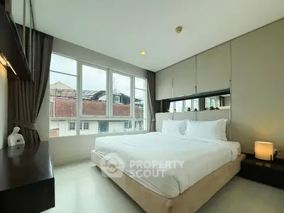 Spacious bedroom with large windows and modern decor