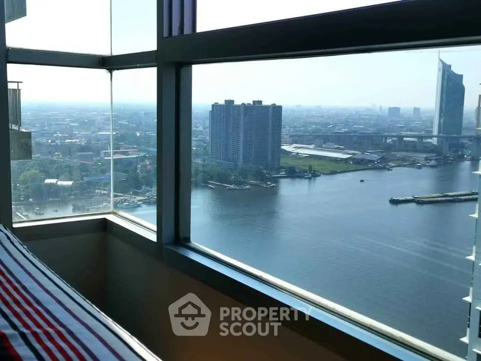 Stunning high-rise view from a modern apartment overlooking a river and cityscape.
