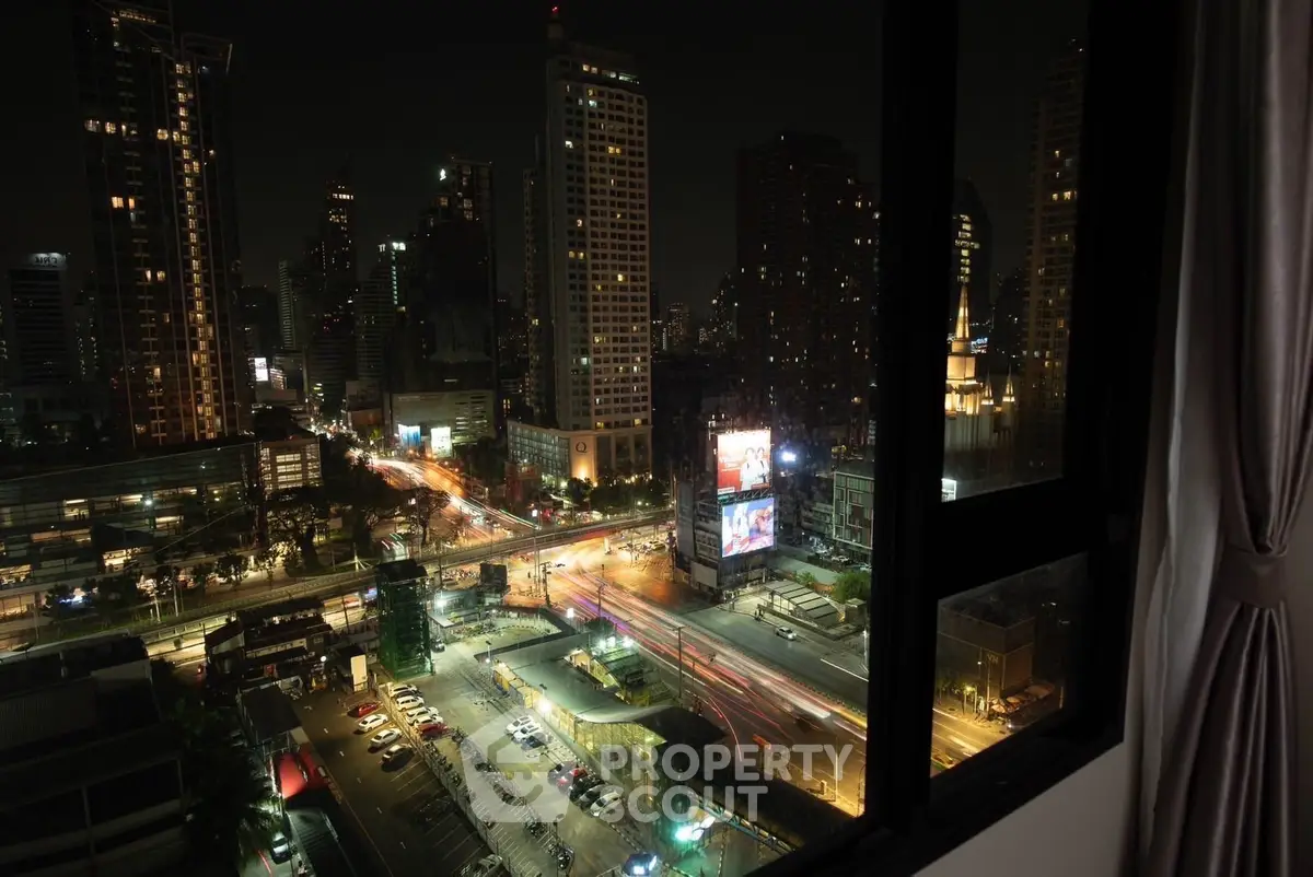Stunning cityscape view from a high-rise apartment window at night, showcasing vibrant urban life.