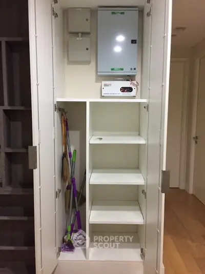 Spacious storage closet with cleaning supplies and shelving in modern apartment.