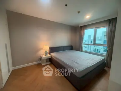 Spacious bedroom with modern design and large window offering city views
