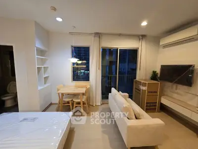 Modern living room with dining area and balcony access in a stylish apartment.