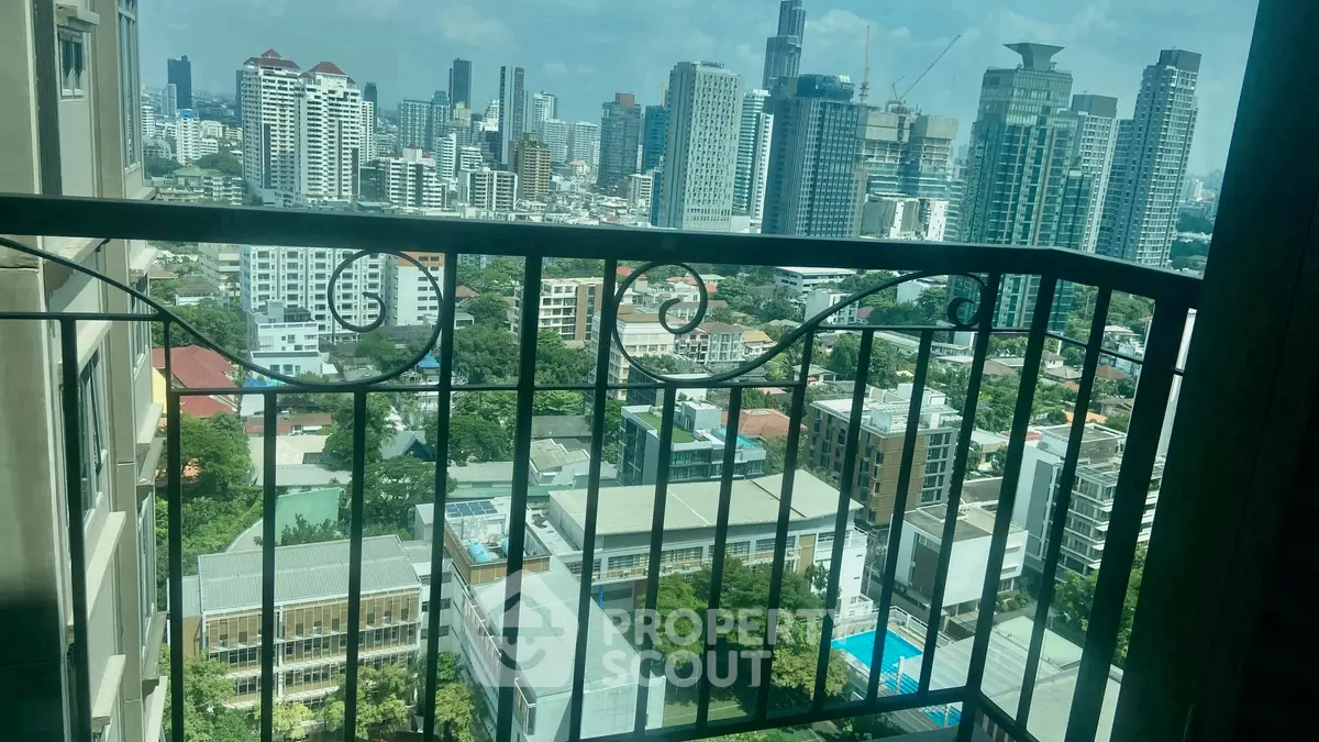 Stunning cityscape view from a high-rise balcony, showcasing urban skyline and lush greenery.