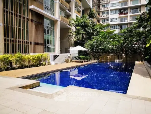Luxurious apartment complex with stunning outdoor pool and lush greenery