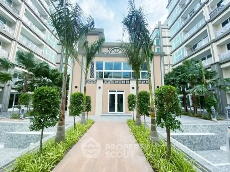Luxurious modern building entrance with lush landscaping and palm trees