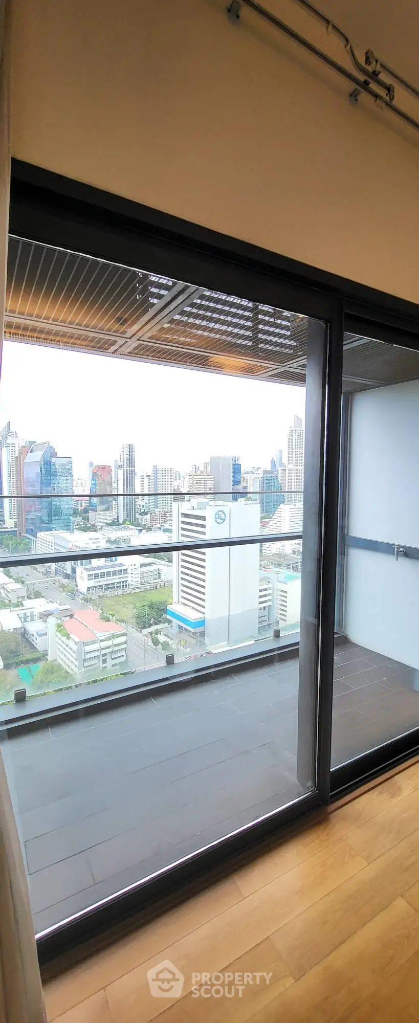 Stunning city view from modern apartment balcony with glass doors