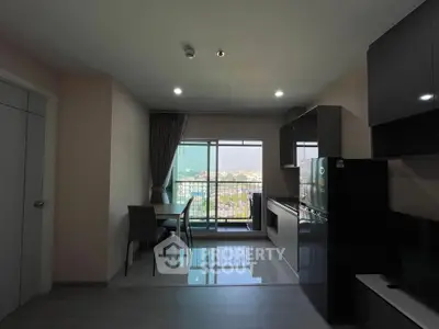 Modern apartment with open kitchen and balcony view, featuring sleek cabinetry and dining area.