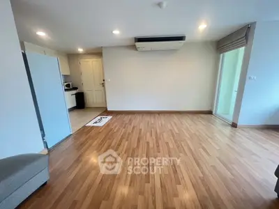 Spacious living room with wooden flooring and modern air conditioning unit