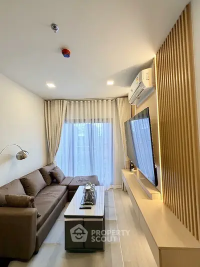 Modern living room with sleek design, featuring a large TV, comfortable sofa, and stylish decor.