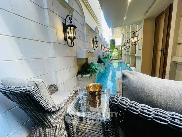 Luxurious poolside seating area with elegant wicker chairs and ambient lighting.