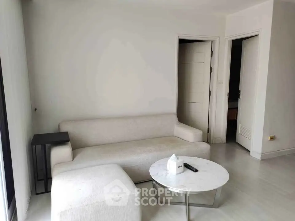Modern minimalist living room with white sofa and sleek coffee table, perfect for urban living.