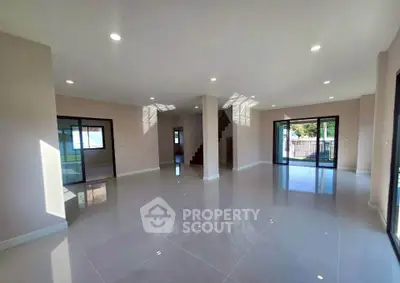 Spacious modern living room with large windows and glossy tile flooring