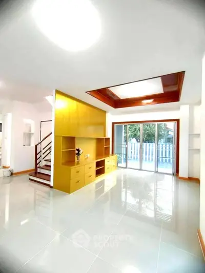 Spacious modern living room with large windows and built-in wooden shelving