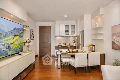 Modern living room with open kitchen, elegant dining area, and large TV, featuring sleek wooden flooring.