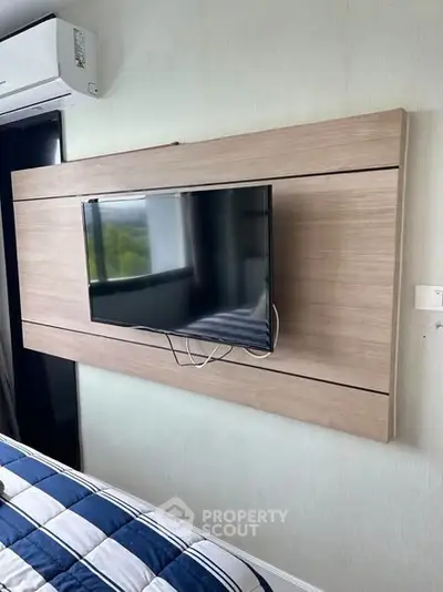 Modern bedroom with wall-mounted TV and air conditioning unit