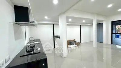 Modern open-layout kitchen with sleek black countertops and gas stove in a spacious interior.