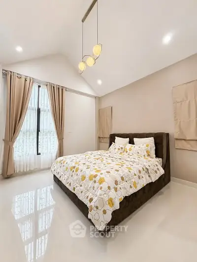 Spacious bedroom with modern decor and large window for natural light