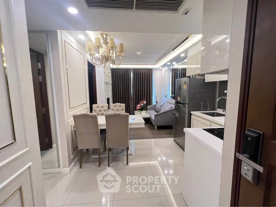 Modern open-layout kitchen and dining area with elegant lighting and sleek appliances.