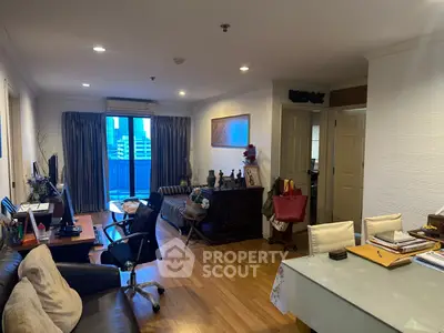 Spacious living room with modern decor and city view balcony in urban apartment.