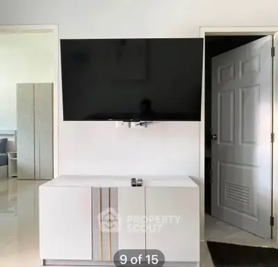 Modern living room with wall-mounted TV and sleek cabinet