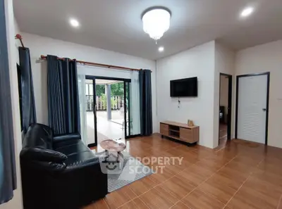 Spacious living room with modern decor and outdoor view, perfect for family gatherings.