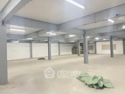 Spacious industrial warehouse with high ceilings and ample open floor space.