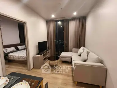Modern living room with cozy sofa and city view, adjacent to a stylish bedroom.