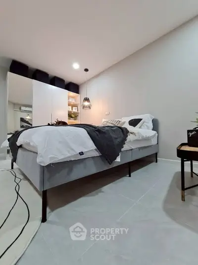 Modern bedroom with stylish decor and cozy ambiance, featuring a comfortable bed and elegant lighting.