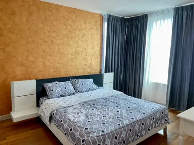 Modern bedroom with stylish decor and natural light, featuring a comfortable bed and elegant curtains.