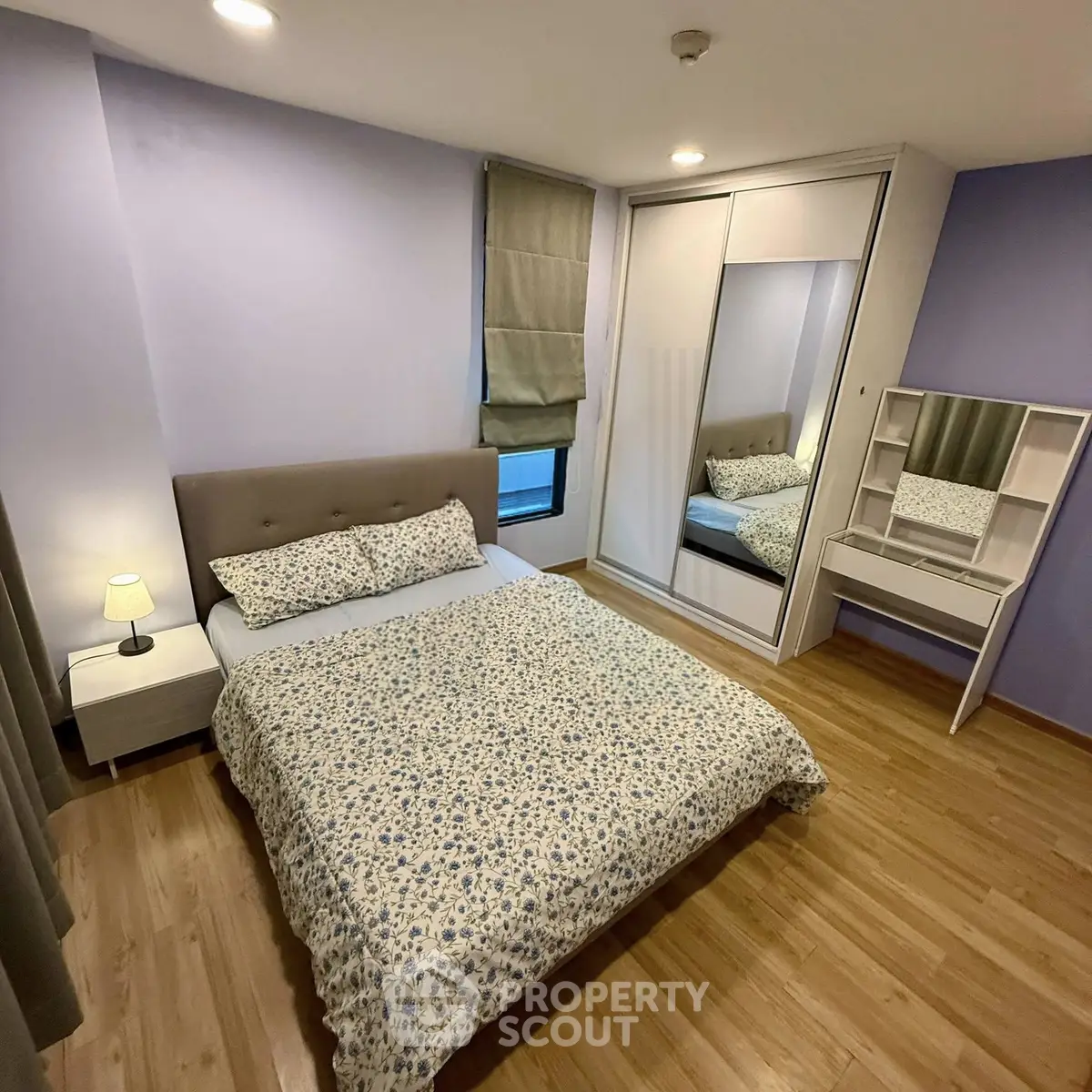 Cozy bedroom with wooden flooring, mirrored wardrobe, and elegant decor in modern apartment.