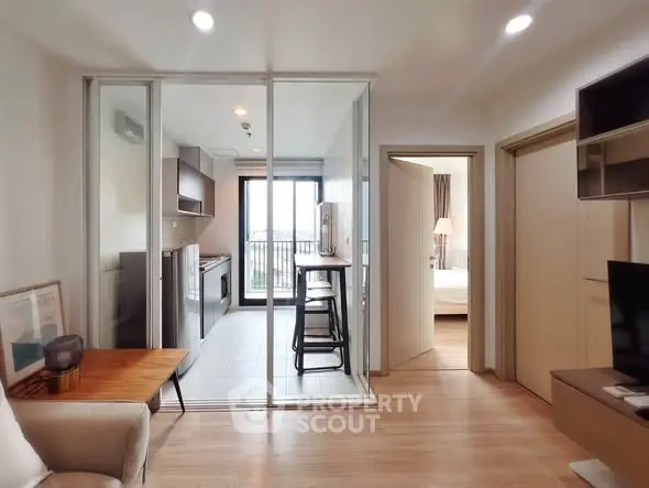 Modern apartment interior with open kitchen and cozy living area, featuring sleek design and natural light.