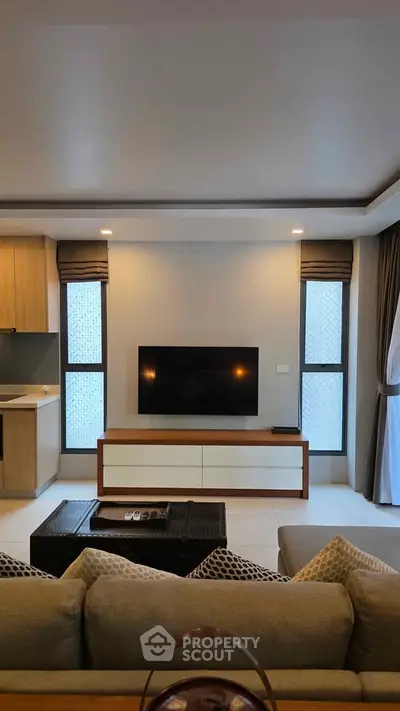 Modern living room with sleek TV setup and cozy seating area, perfect for relaxation and entertainment.