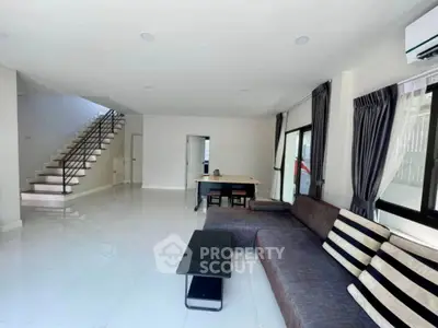 Spacious modern living room with sleek staircase and stylish furniture