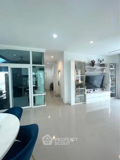 Spacious modern living room with sleek design and ample natural light, featuring a stylish entertainment center.