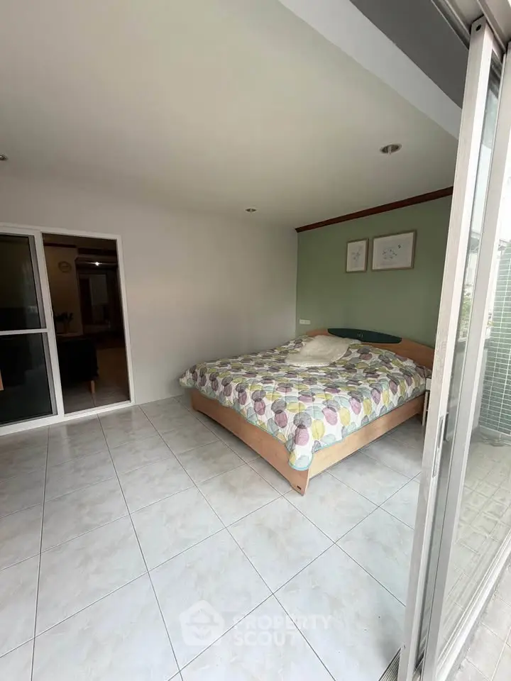 Spacious bedroom with large windows and modern decor, perfect for comfortable living.