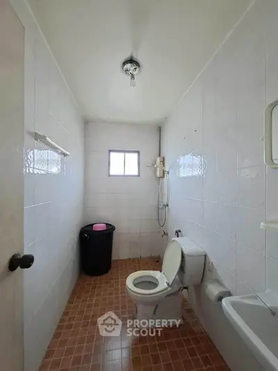 Simple bathroom with white tiles and basic fixtures