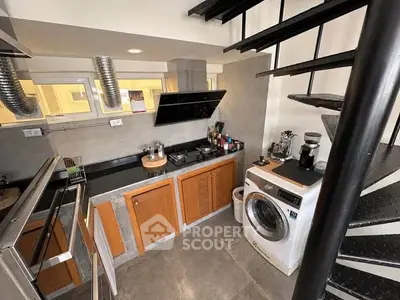 Modern kitchen with spiral staircase and washing machine, featuring sleek appliances and stylish cabinetry.