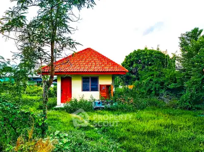 Charming small house with red roof surrounded by lush greenery, perfect for nature lovers.