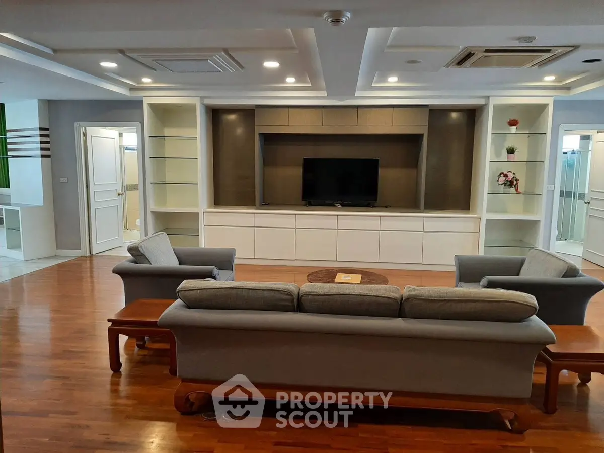 Spacious living room with elegant wooden flooring and modern furniture, perfect for relaxation and entertainment.