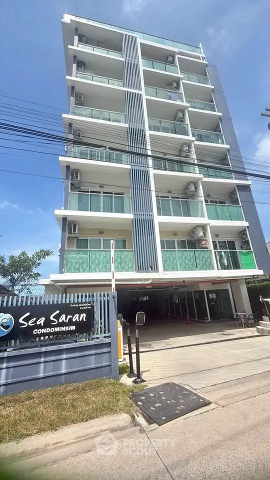 Modern condominium building with sleek design and balconies, ideal for urban living near the sea.