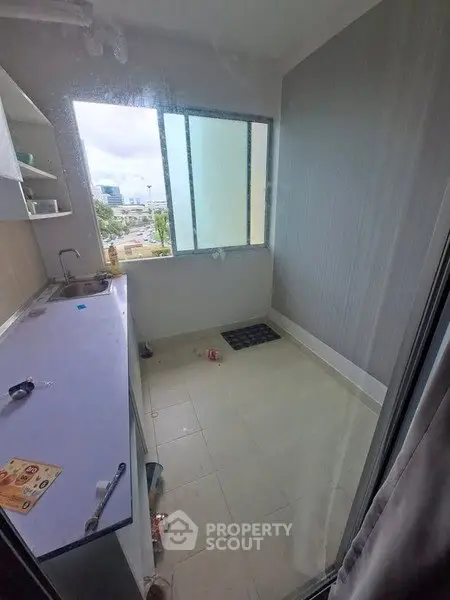 Compact kitchen with window view, featuring minimalistic design and tiled flooring.