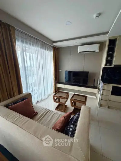 Modern living room with large window, stylish furniture, and wall-mounted TV in a cozy apartment.