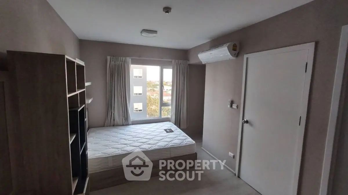 Cozy bedroom with natural light and air conditioning in modern apartment.