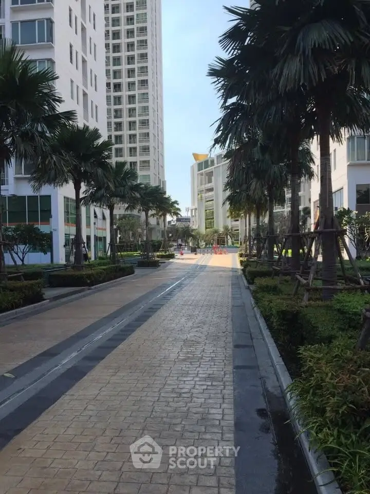 Modern residential complex with lush landscaping and tall buildings, offering a serene urban living environment.