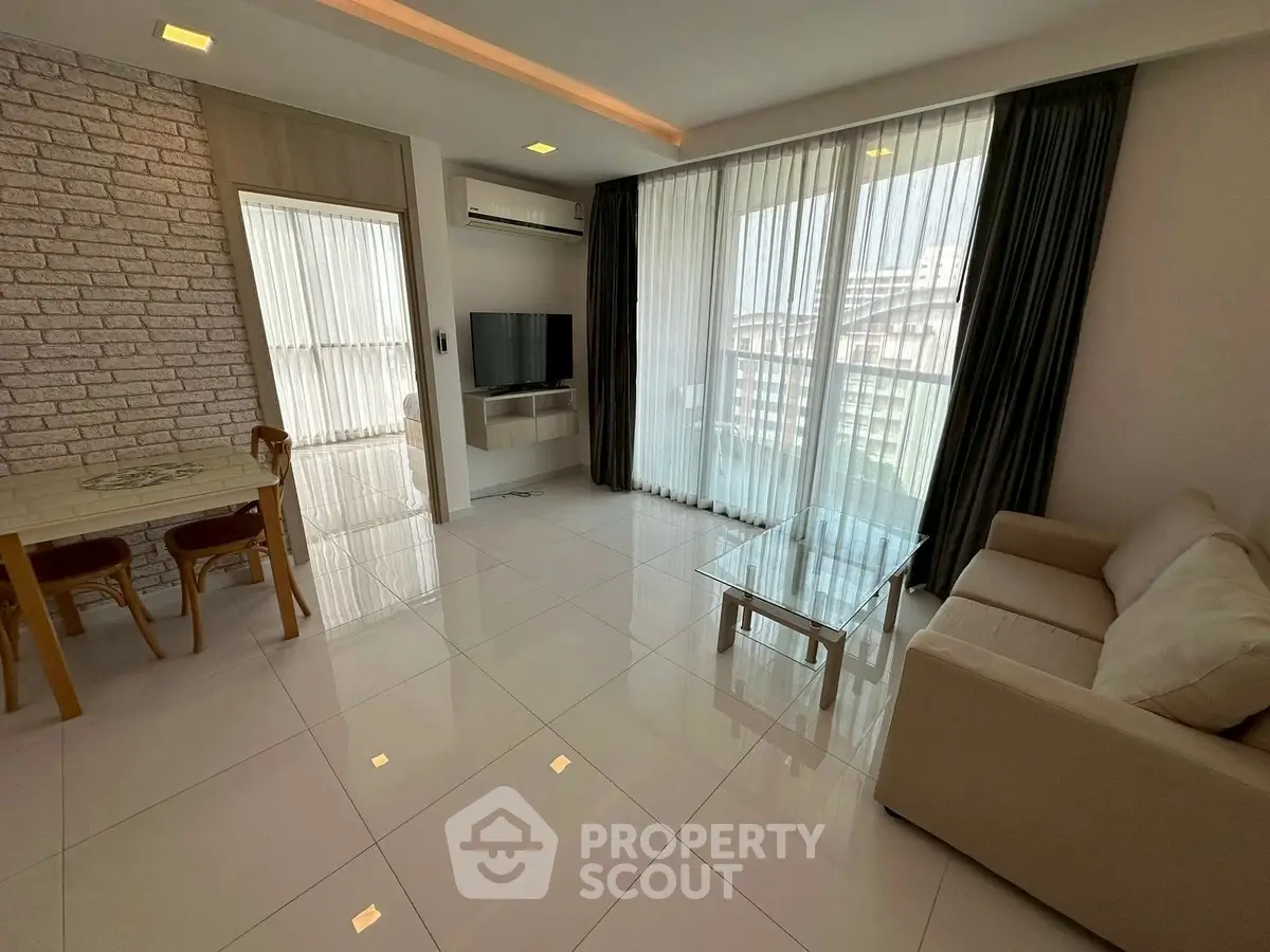 Modern living room with sleek design, large windows, and stylish furniture in a bright apartment.