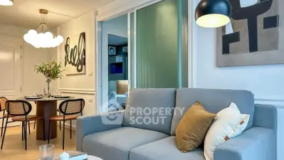 Stylish living room with modern decor and dining area in open layout apartment.