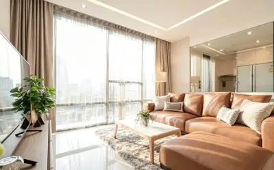 Luxurious modern living room with large windows and leather sofa in high-rise apartment.