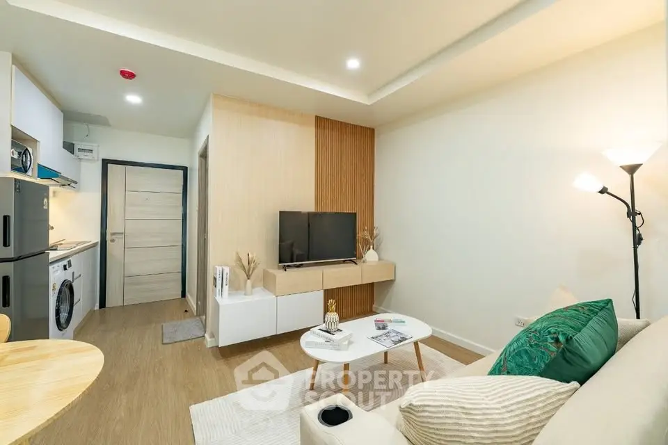 Modern living room with stylish decor and open kitchen layout in a cozy apartment.