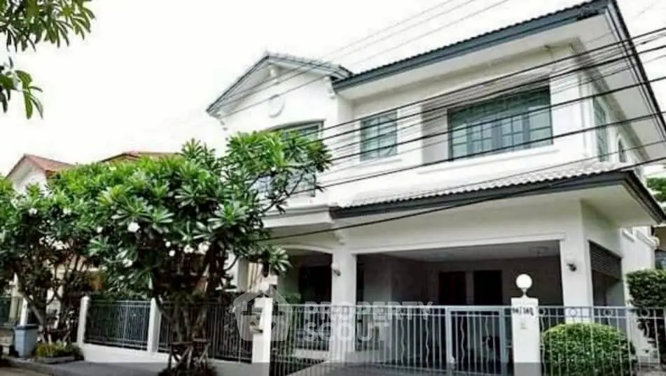 Charming two-story house with lush greenery and modern design in a serene neighborhood.